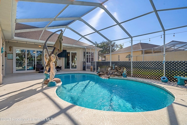 view of swimming pool featuring a lanai and a patio area