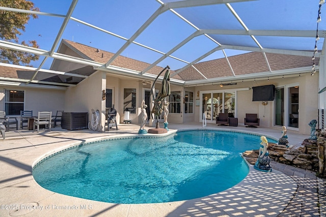 view of pool featuring ceiling fan, a patio, glass enclosure, and central AC