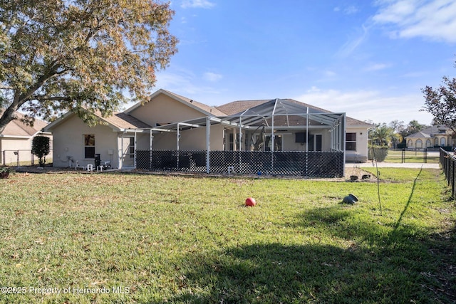 rear view of house with a lanai and a lawn