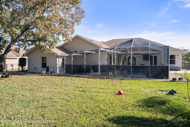 rear view of property featuring a lanai and a yard