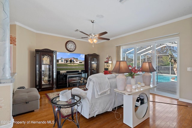 living room featuring ornamental molding, ceiling fan, and hardwood / wood-style floors