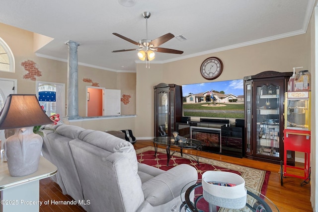 living room with hardwood / wood-style floors, ceiling fan, crown molding, and decorative columns