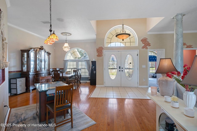 foyer with ornamental molding, french doors, and ornate columns