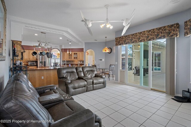 tiled living room featuring ceiling fan and a healthy amount of sunlight