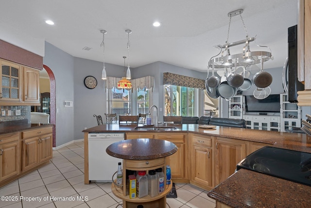 kitchen featuring white dishwasher, an island with sink, light tile patterned flooring, and sink