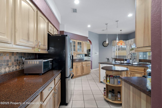 kitchen with sink, decorative light fixtures, light tile patterned flooring, tasteful backsplash, and dishwashing machine