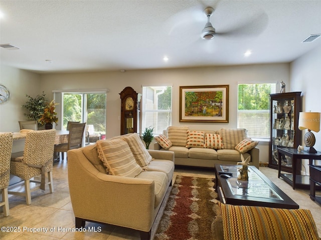 living room with ceiling fan, light tile patterned floors, and a healthy amount of sunlight