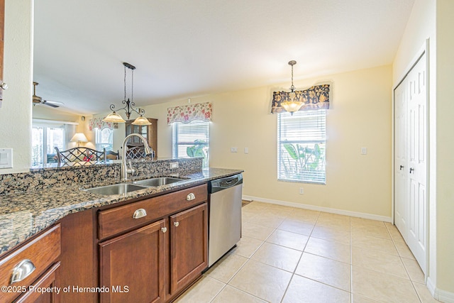 kitchen with a sink, dark stone counters, brown cabinets, and dishwasher