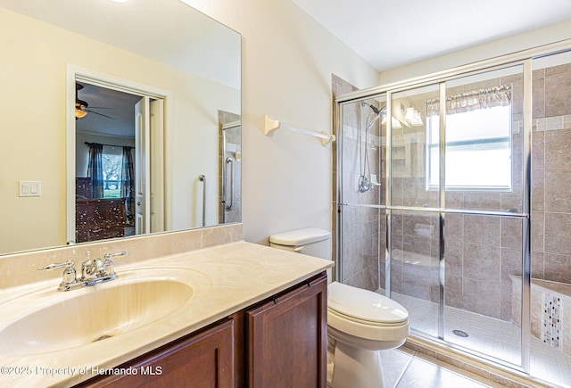 full bathroom with a healthy amount of sunlight, a stall shower, toilet, and vanity