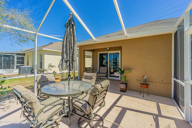 view of patio / terrace featuring outdoor dining area, central AC, and a lanai