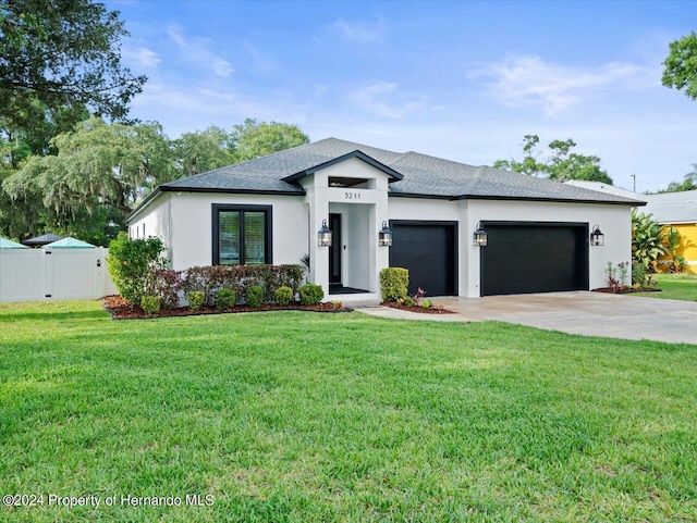 view of front of home with a front yard and a garage