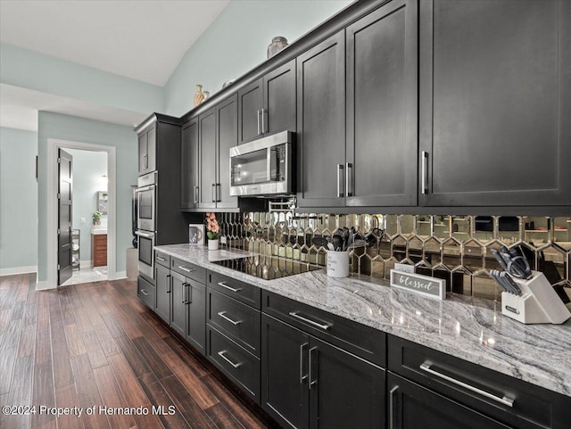 kitchen featuring dark hardwood / wood-style flooring, light stone countertops, and appliances with stainless steel finishes