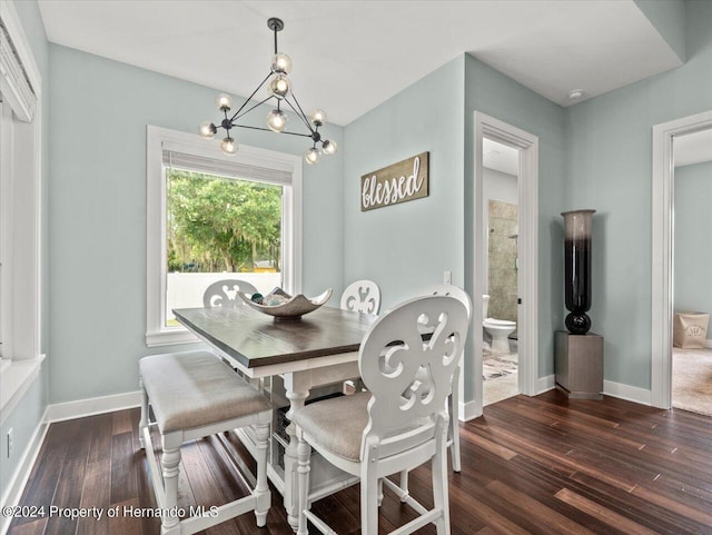 dining room with dark hardwood / wood-style floors and an inviting chandelier