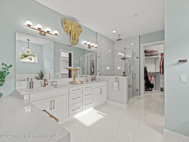 bathroom featuring a shower with door and vanity