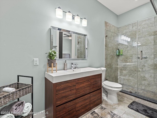 bathroom with ceiling fan, vanity, a shower with shower door, and toilet