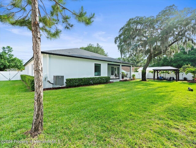 back of house with a gazebo, central AC, and a lawn