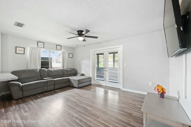 living room featuring french doors, a textured ceiling, ceiling fan, and wood-type flooring