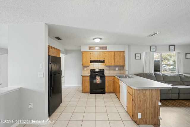 kitchen featuring black appliances, sink, decorative backsplash, light tile patterned floors, and kitchen peninsula