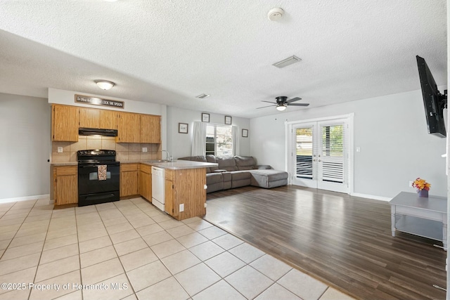 kitchen with dishwasher, sink, tasteful backsplash, black electric range oven, and kitchen peninsula