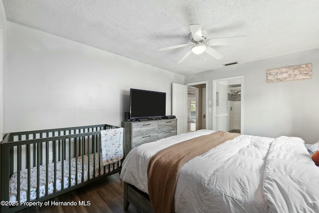 bedroom featuring ceiling fan, dark hardwood / wood-style floors, a textured ceiling, and connected bathroom