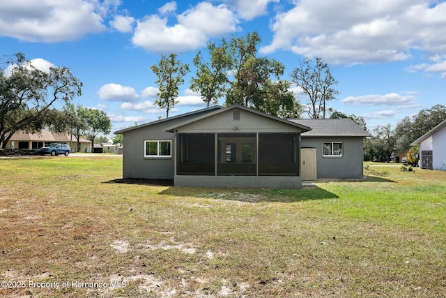 rear view of property featuring a lawn and a sunroom