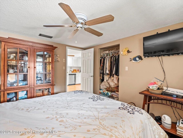 bedroom with ceiling fan, a textured ceiling, and a closet