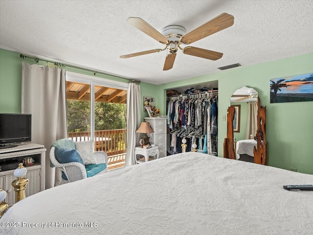 bedroom featuring access to exterior, a textured ceiling, a closet, and ceiling fan