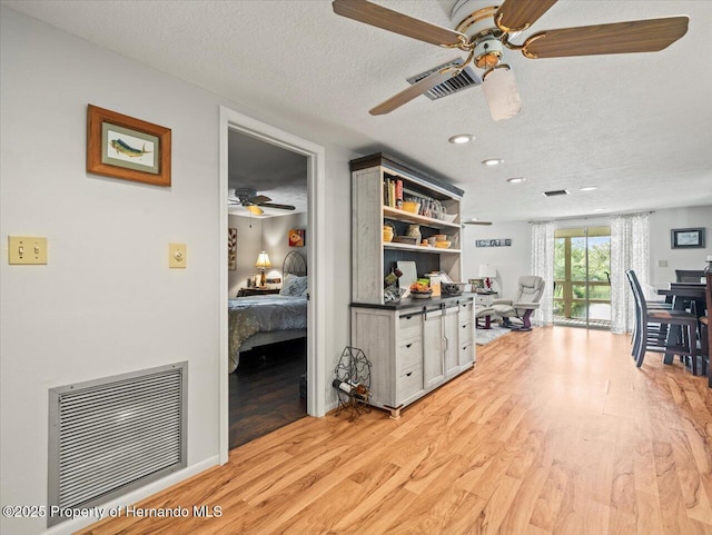 office space with a textured ceiling, light hardwood / wood-style flooring, and ceiling fan