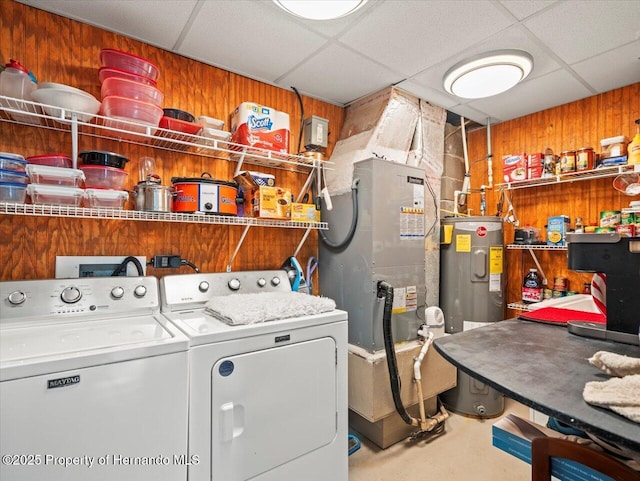 laundry room with electric water heater, wooden walls, and independent washer and dryer