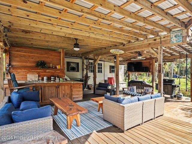 wooden terrace featuring an outdoor living space, a grill, and a wet bar