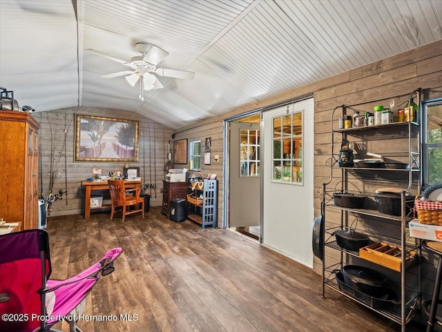 home office featuring vaulted ceiling, ceiling fan, wood-type flooring, and wood walls