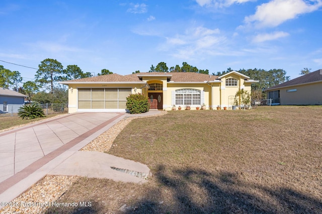 ranch-style home featuring a front lawn and a garage