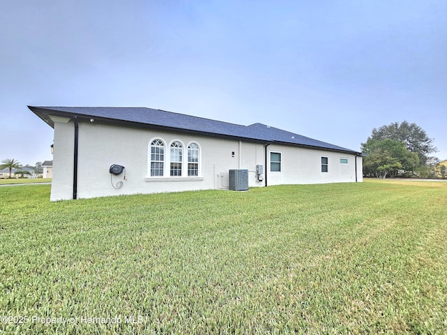 back of property with cooling unit and a yard