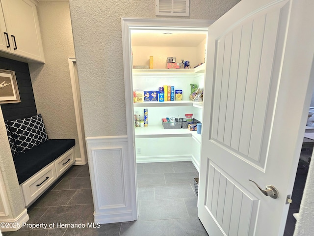 mudroom with dark tile patterned flooring