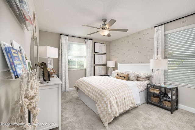 carpeted bedroom featuring a textured ceiling and ceiling fan