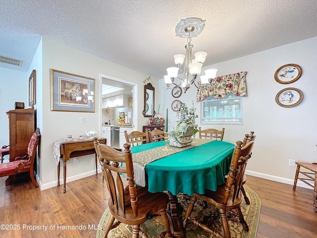 dining area featuring a textured ceiling, a chandelier, and hardwood / wood-style flooring