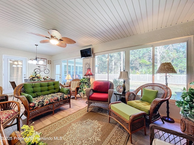 sunroom with ceiling fan with notable chandelier and wooden ceiling