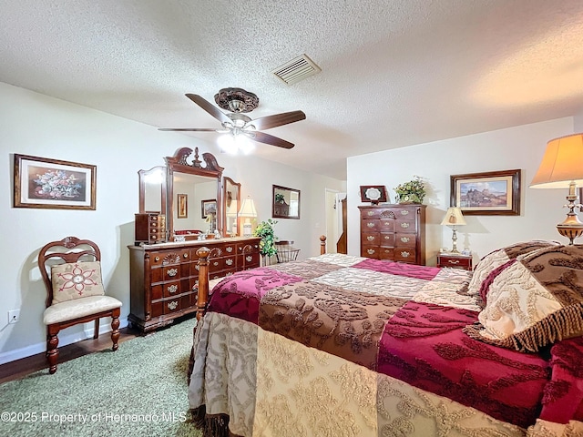 bedroom with ceiling fan and a textured ceiling