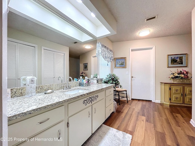 bathroom featuring hardwood / wood-style flooring, a textured ceiling, and vanity