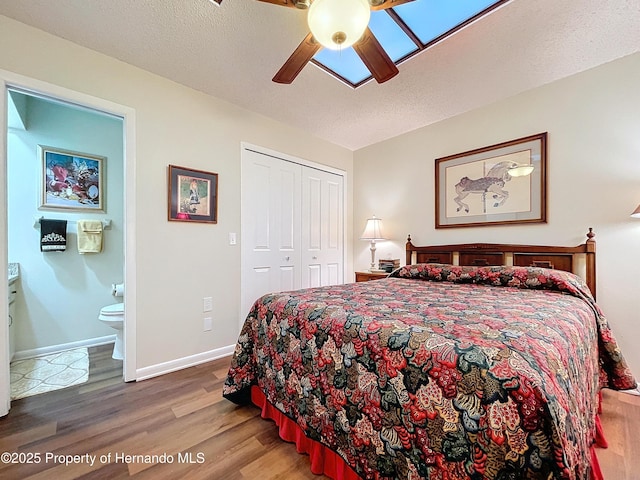 bedroom with a textured ceiling, a closet, ceiling fan, and hardwood / wood-style flooring