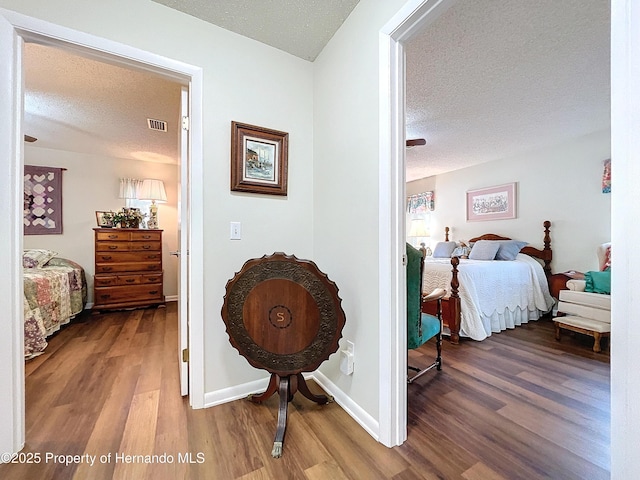 bedroom featuring hardwood / wood-style flooring and a textured ceiling