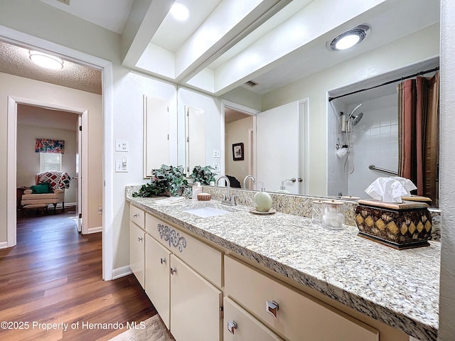 bathroom with a shower with curtain, a textured ceiling, hardwood / wood-style floors, and vanity