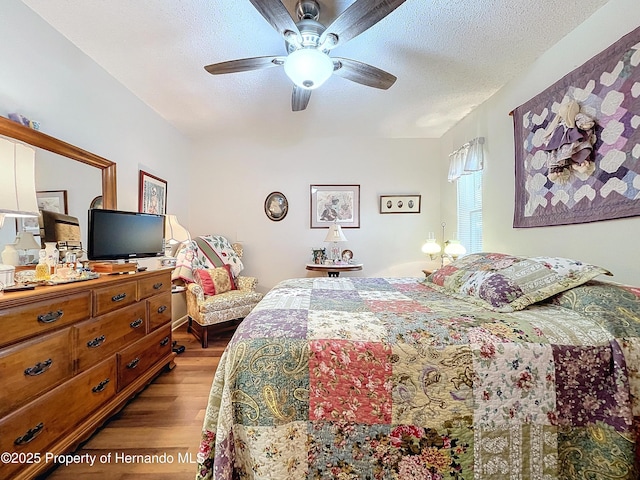 bedroom featuring wood-type flooring, a textured ceiling, and ceiling fan