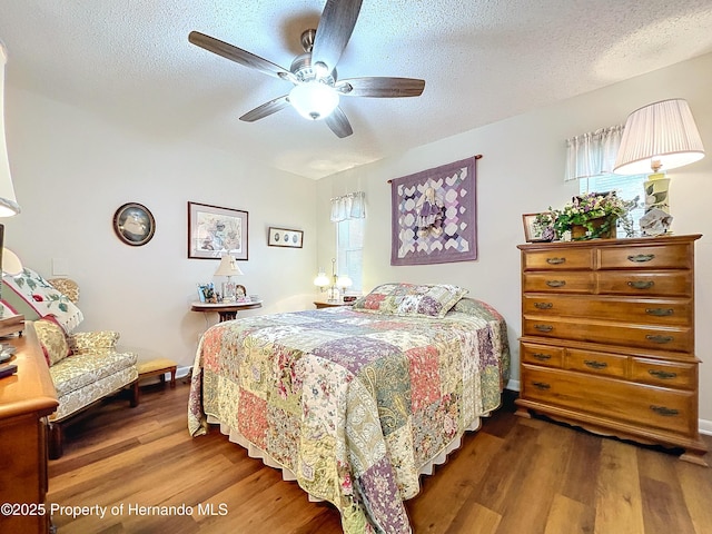 bedroom featuring ceiling fan, a textured ceiling, and hardwood / wood-style flooring