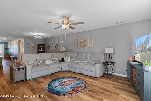 living room featuring ceiling fan and light hardwood / wood-style flooring