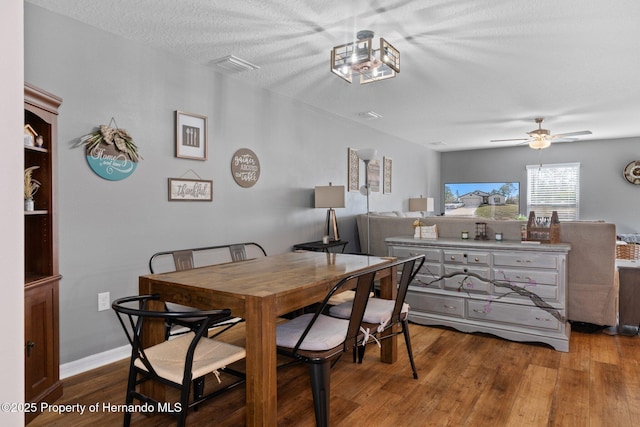 dining room with a textured ceiling, hardwood / wood-style flooring, and ceiling fan