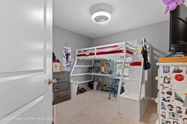 carpeted bedroom featuring a textured ceiling and white refrigerator