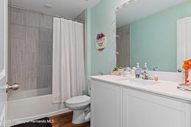 full bathroom featuring hardwood / wood-style floors, vanity, shower / tub combo, and toilet