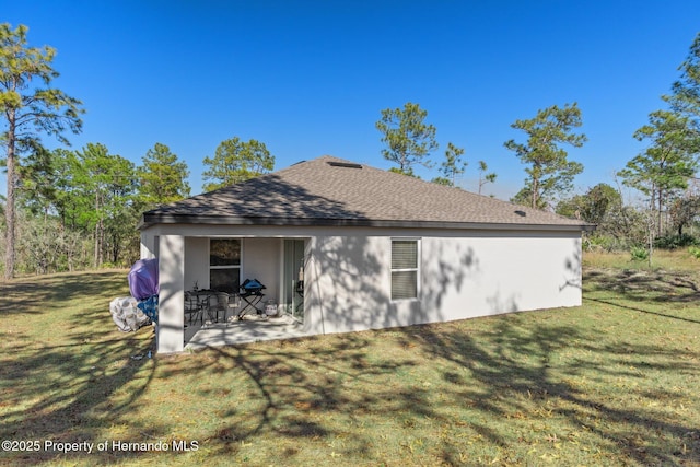 rear view of property with a yard and a patio area