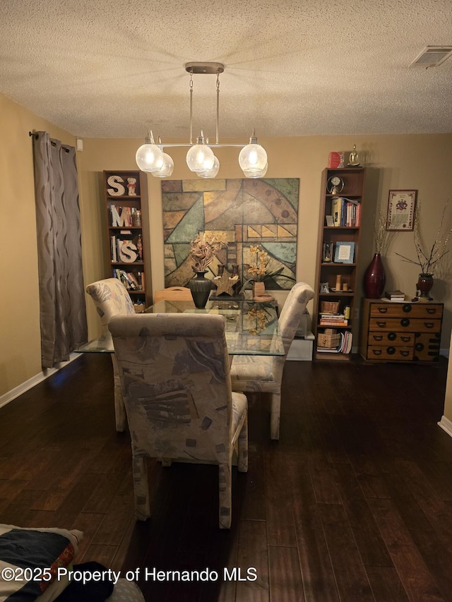 dining space featuring dark hardwood / wood-style flooring and a textured ceiling